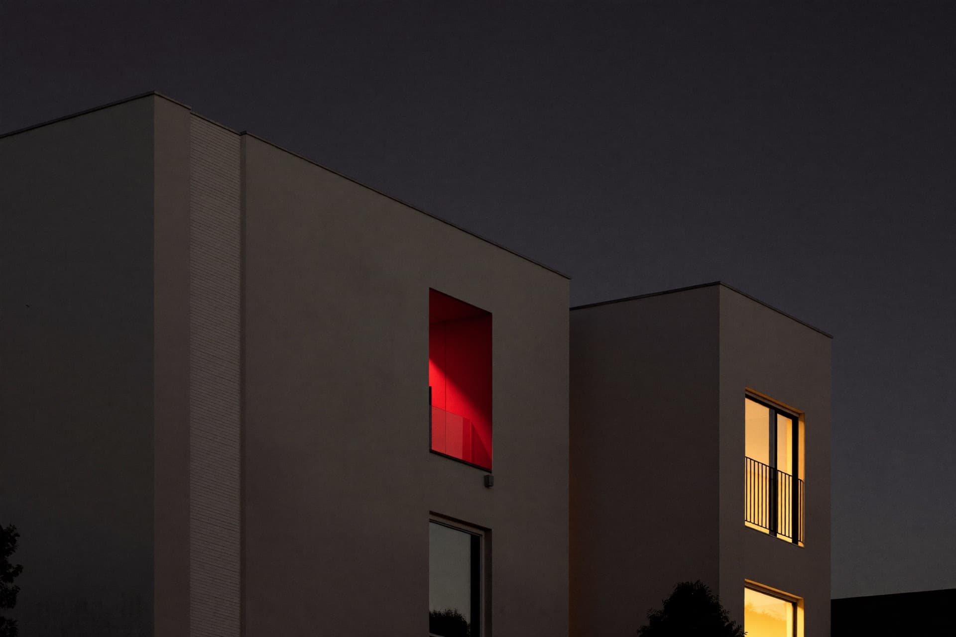 Wohn- und Geschäftshaus mit Glasfassade in der Abenddämmerung